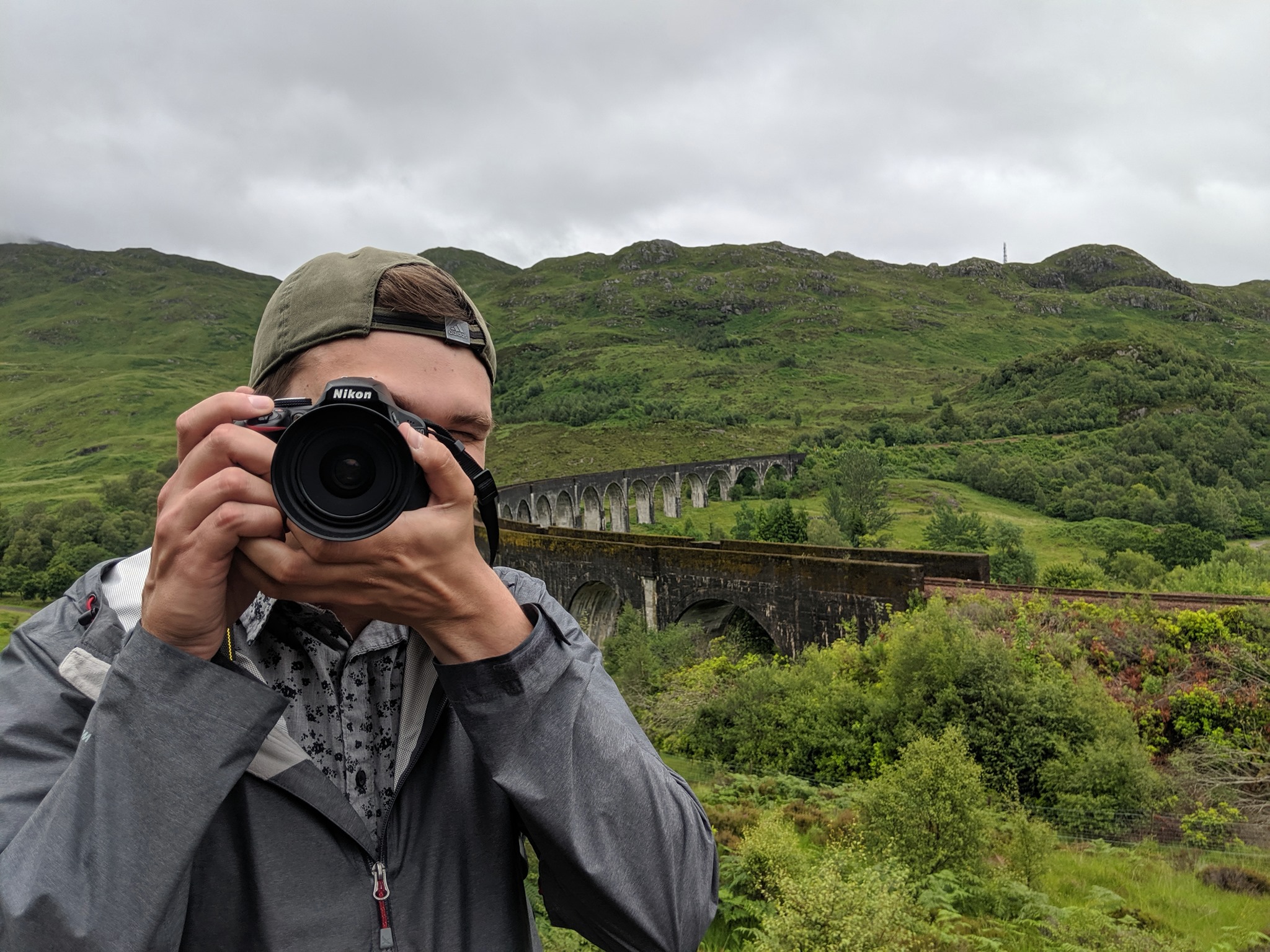 picture of Lucas holding a camera to face and facing viewer